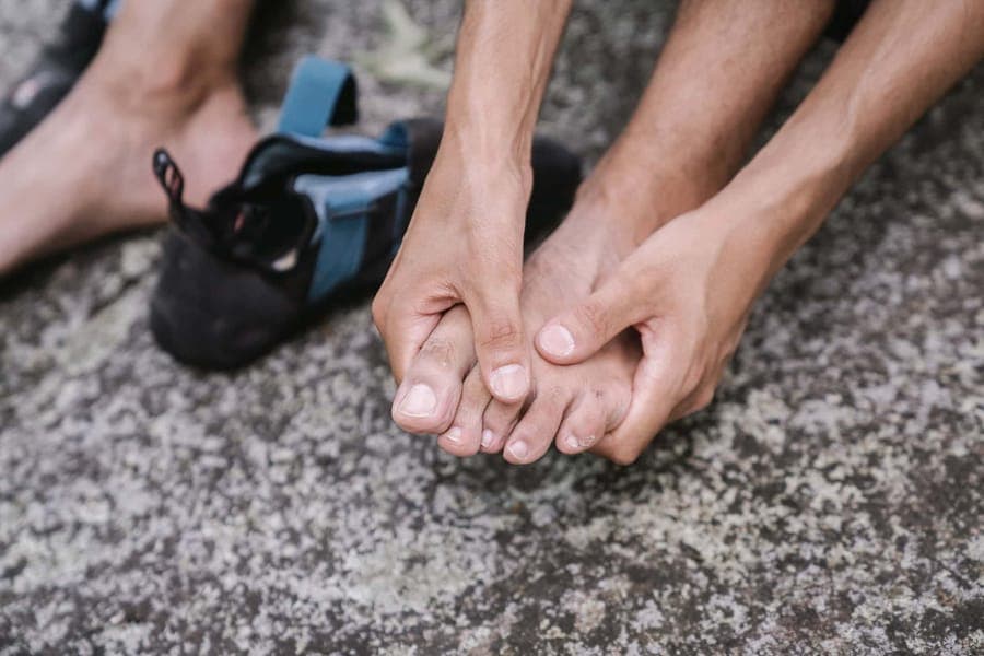 A person massaging their bare feet outdoors